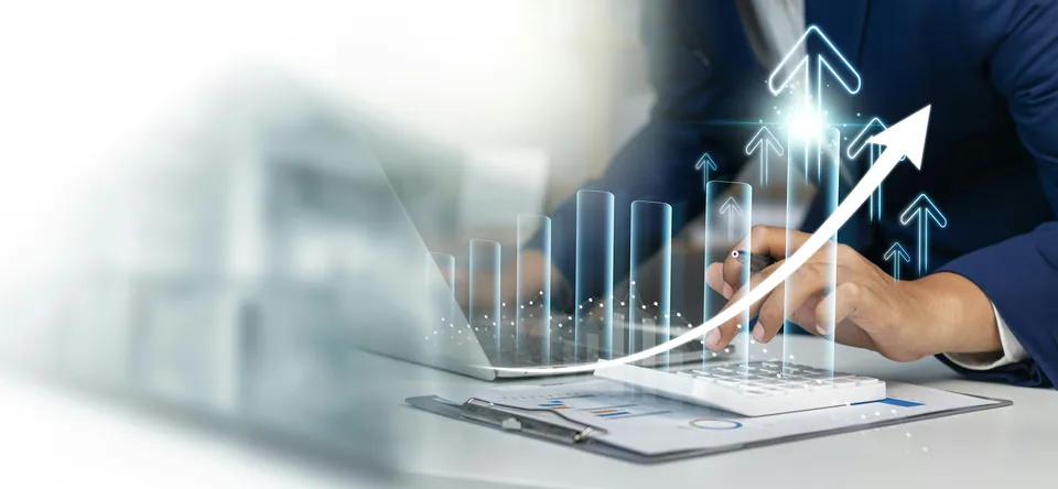 Hand on a laptop with a glowing upward arrow and rising bar chart overlay