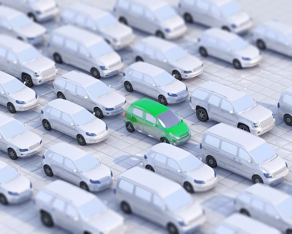 Rows of identical white vans with one green van standing out