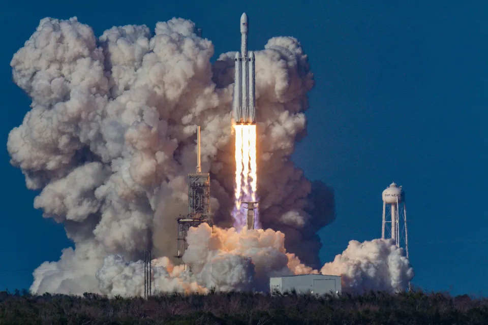 Rocket lifting off from a launch pad in billowing smoke