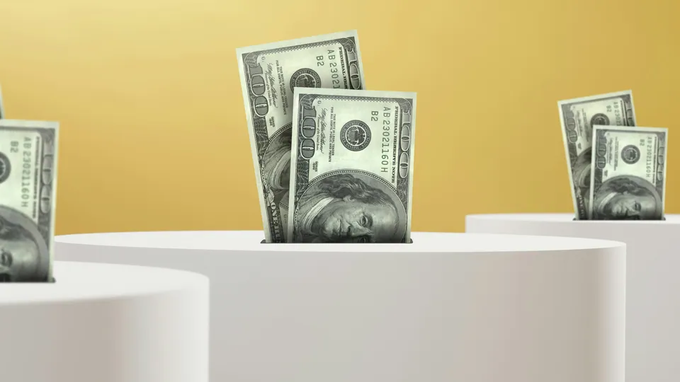 Stacks of hundred-dollar bills rising from white pedestals