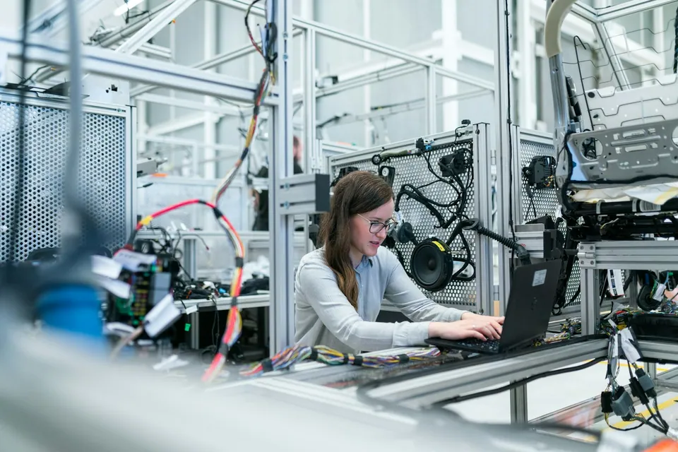 Engineer working on a laptop inside a robotics lab