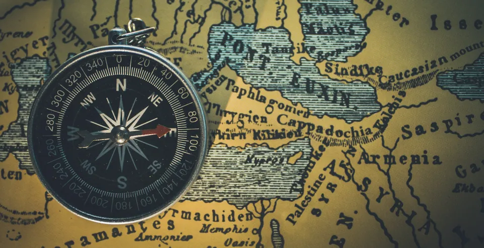 Antique compass resting on an old map