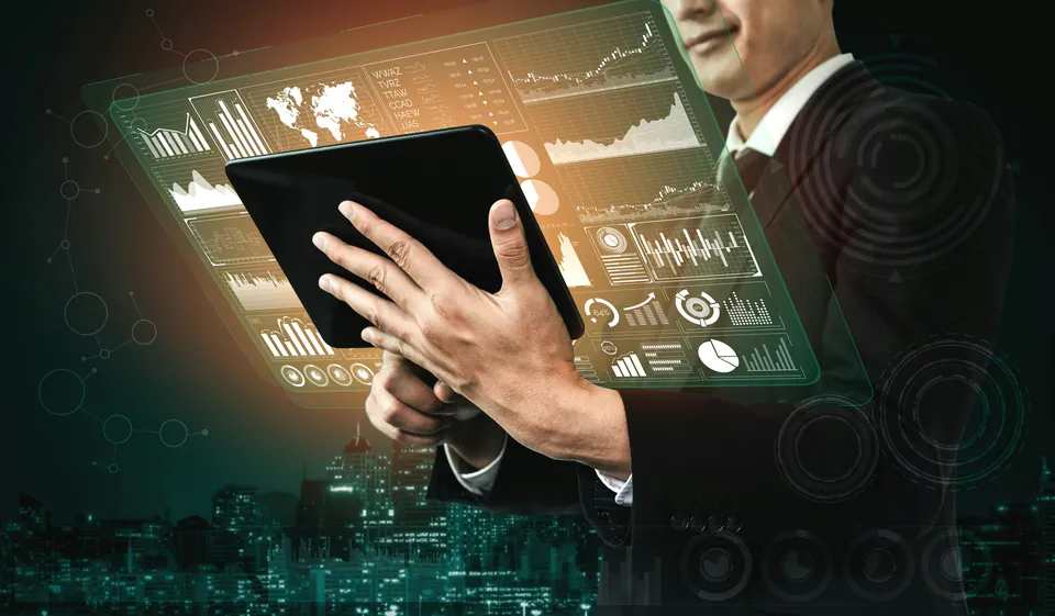Businessman holding a tablet surrounded by floating financial charts