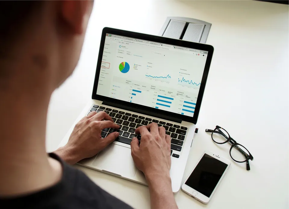 Person typing on a laptop showing an analytics dashboard