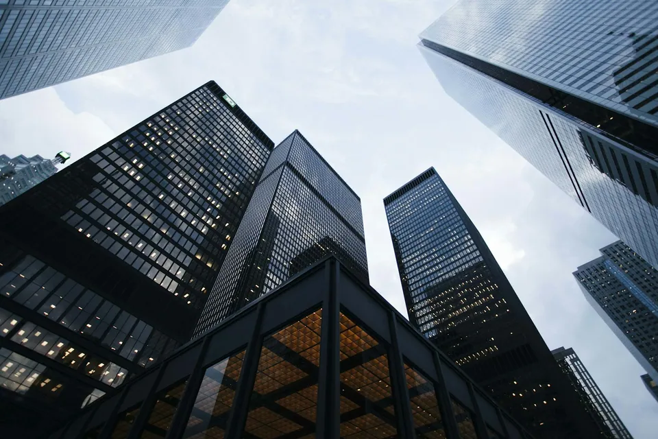 Looking up at dark glass skyscrapers against the sky