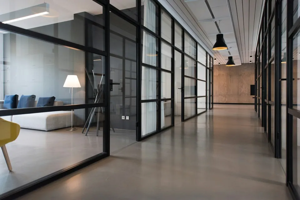 Modern office corridor with glass-walled meeting rooms