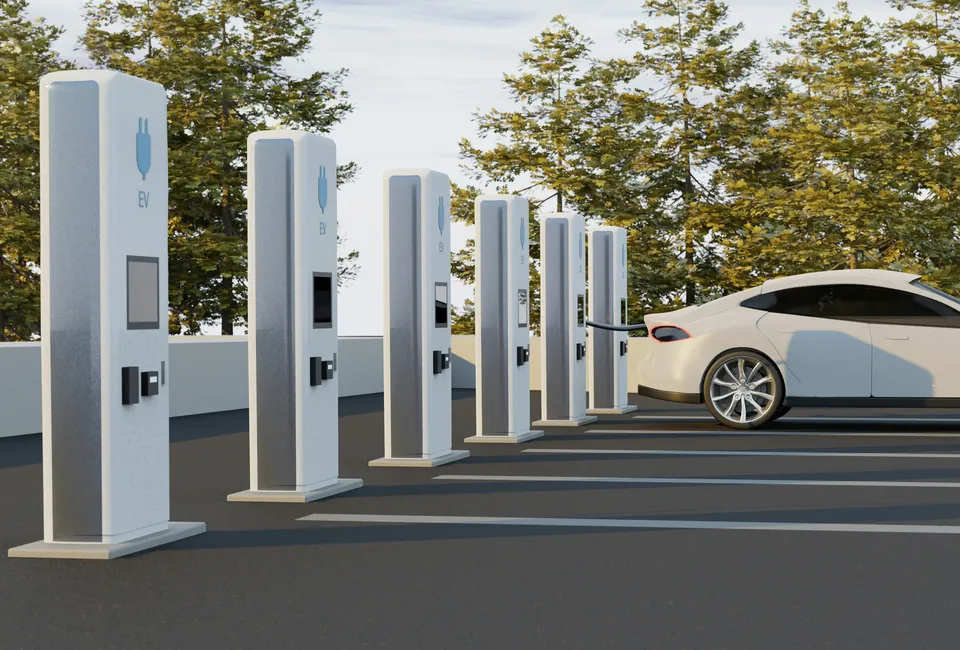Row of electric vehicle charging stations beside a white car