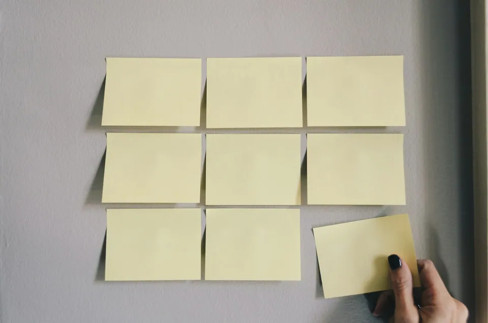 Grid of blank sticky notes on a gray wall