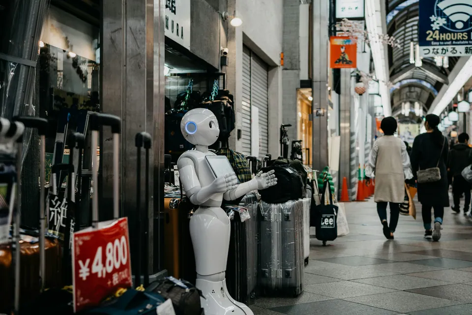 White humanoid robot standing in a shopping arcade