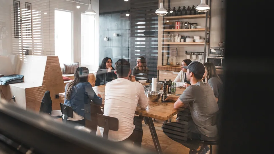 People working at a long table in a cafe-style office