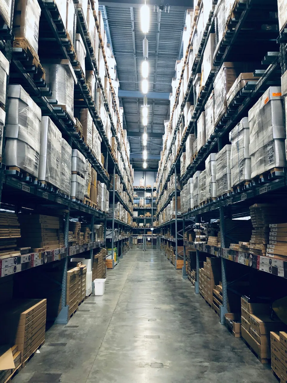 Long warehouse aisle lined with shelves of boxes