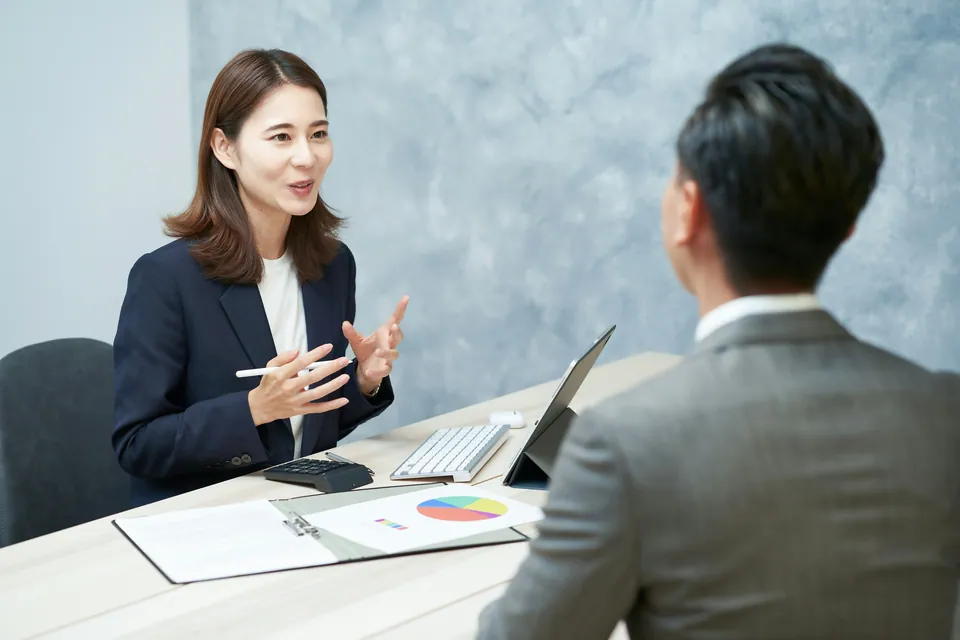 Woman explaining a pie chart to a client across a desk