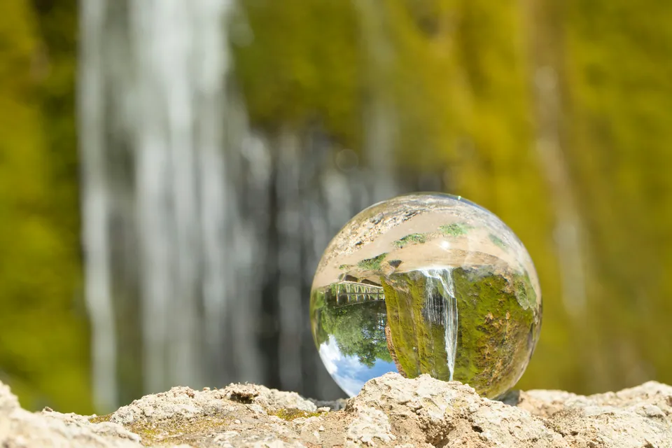 Crystal ball reflecting a waterfall and greenery