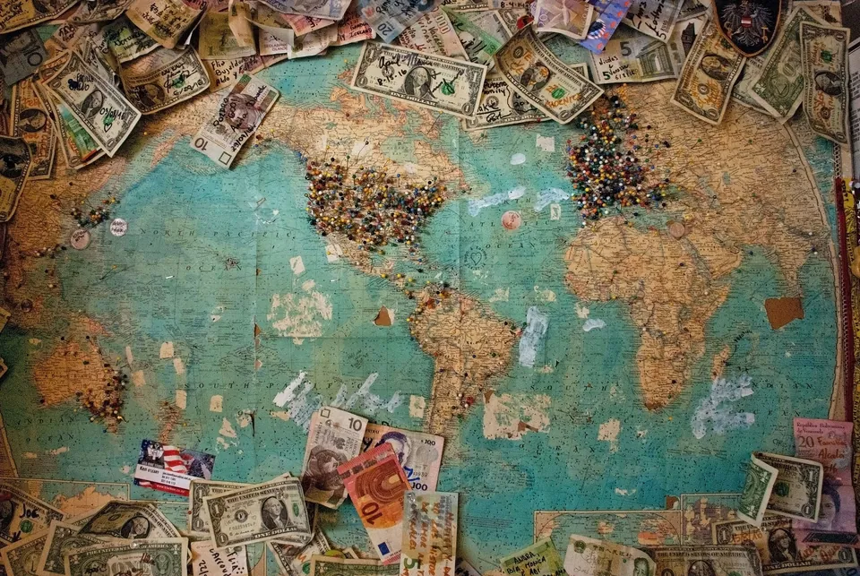 World map covered with banknotes from many countries