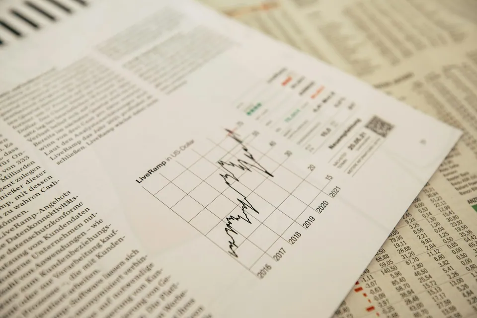 Printed newspaper page with a stock price line chart