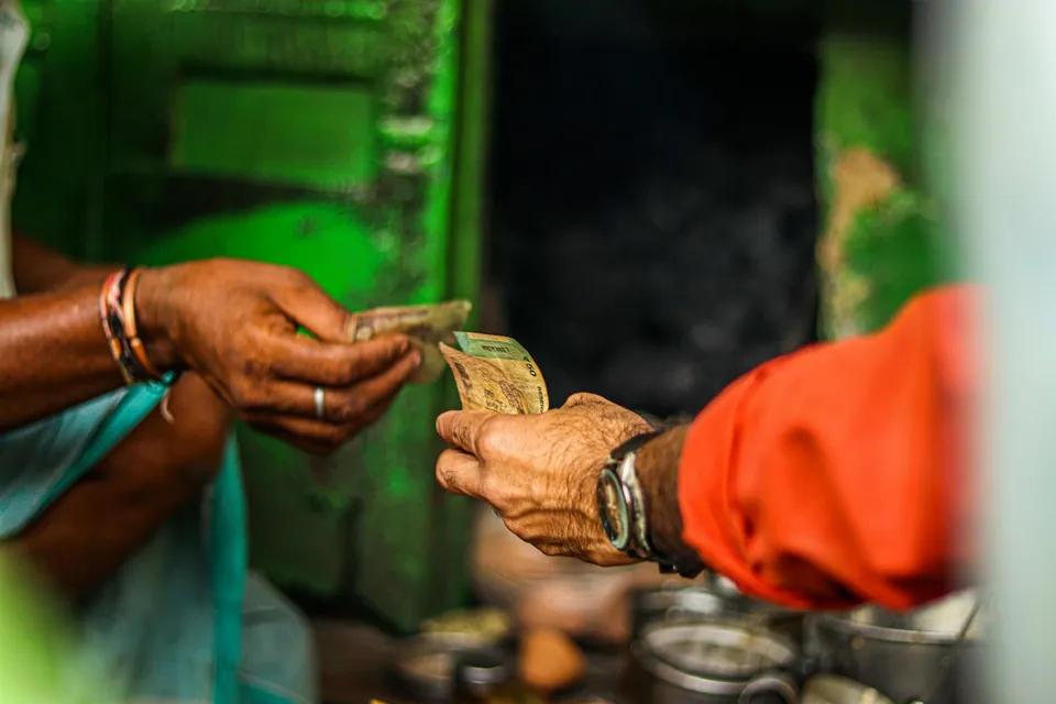 Hands exchanging cash at a market stall