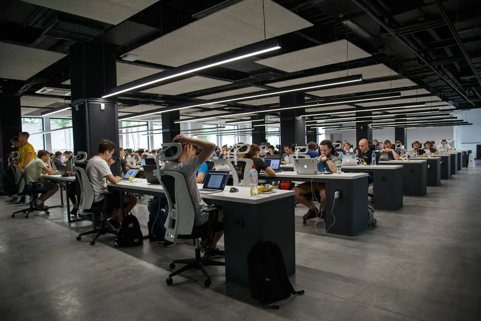 Large open-plan office with rows of people at desks