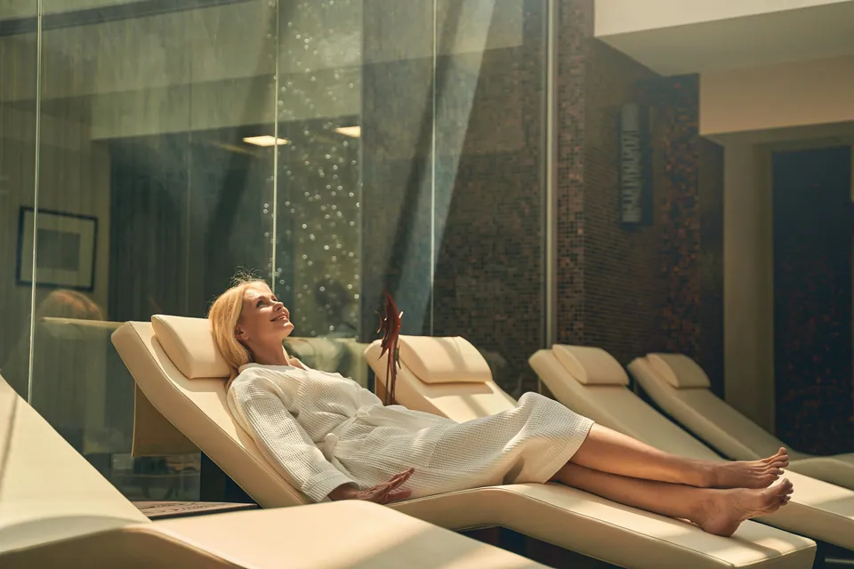 Woman in a robe relaxing on a lounger in a spa