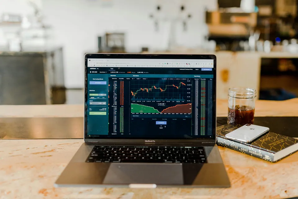 Laptop showing a trading dashboard on a kitchen counter