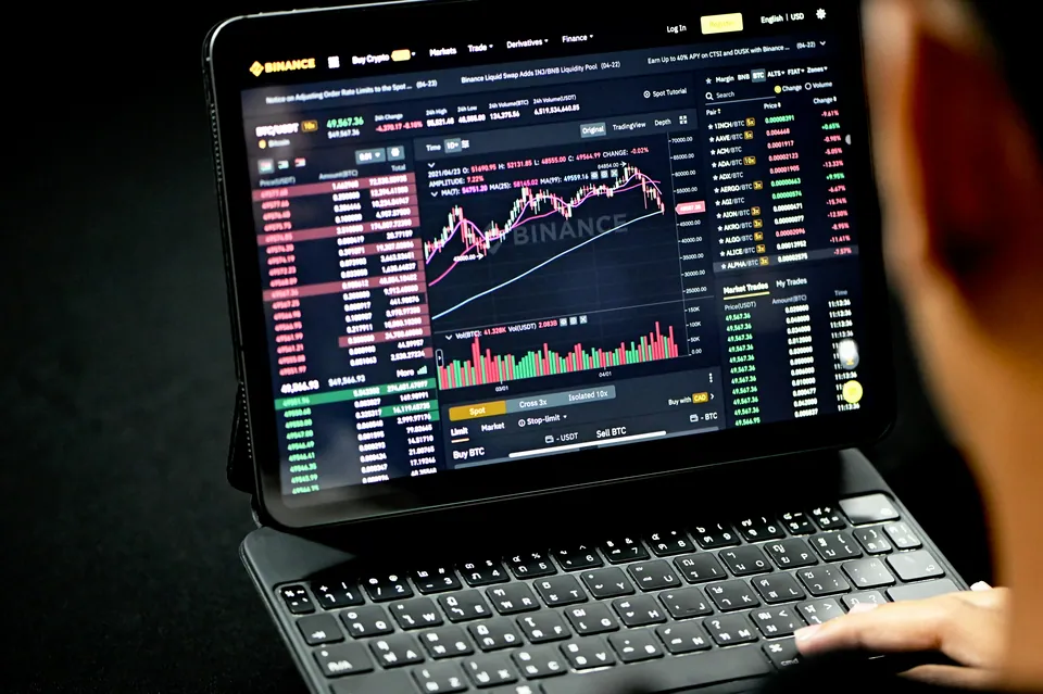 Person using a tablet showing a crypto exchange chart