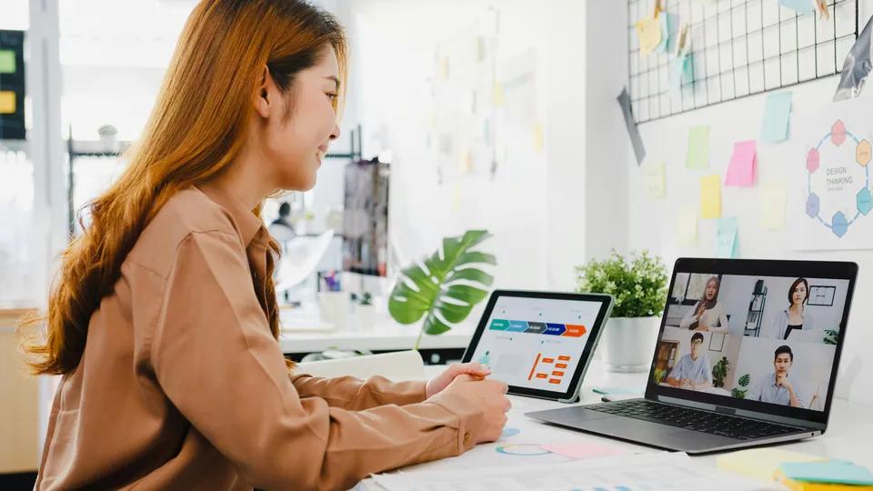 Woman on a video call with colleagues on a laptop