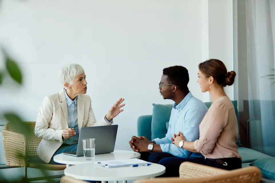Advisor talking with a young couple on a sofa