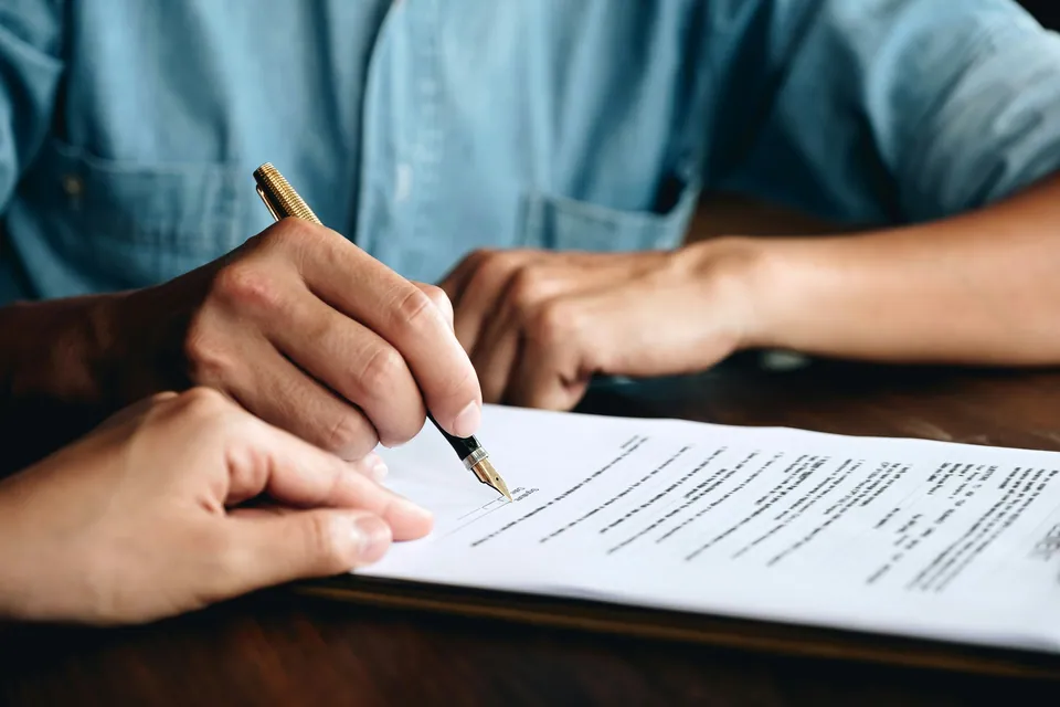 Hand signing a contract with a fountain pen