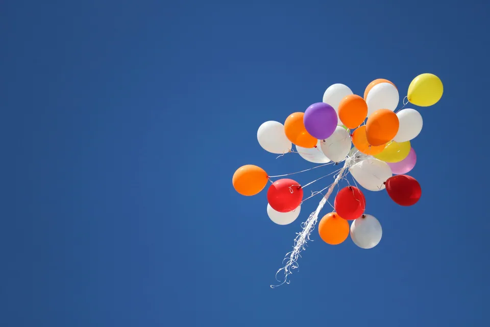 Bunch of colorful balloons floating in a blue sky