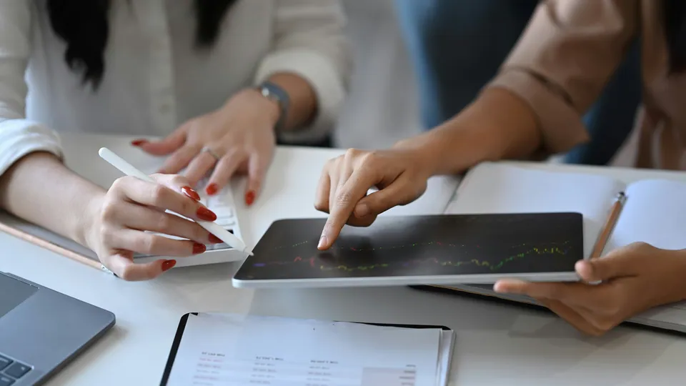 Two people reviewing a chart on a tablet with a stylus