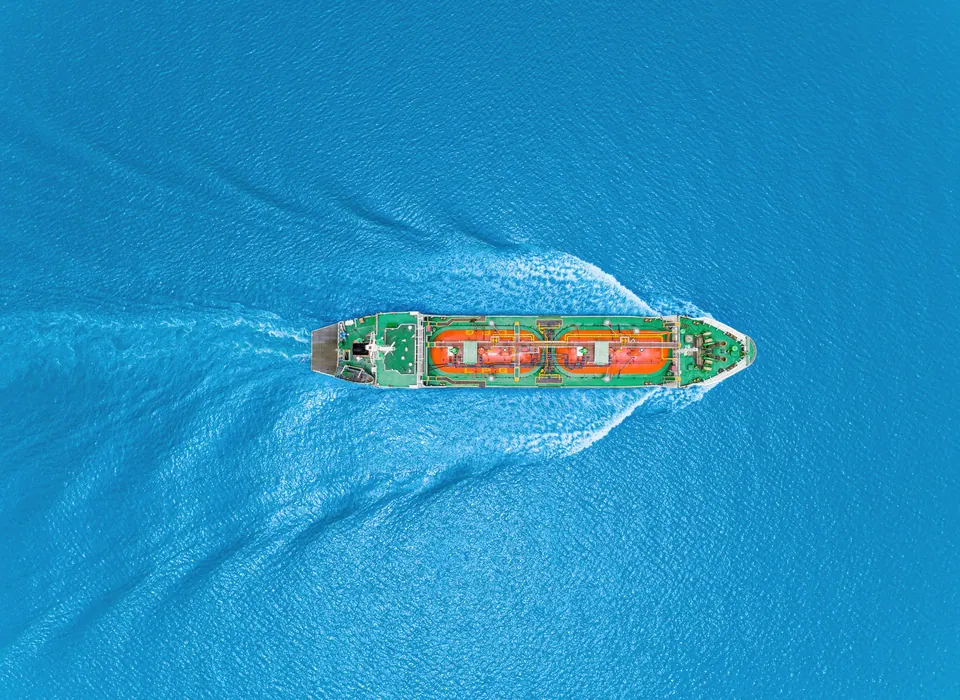 Aerial view of a cargo ship sailing on turquoise water
