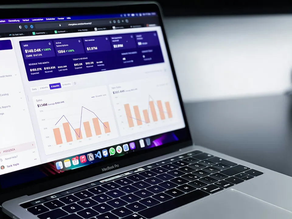 Laptop showing a finance dashboard with bar and line charts