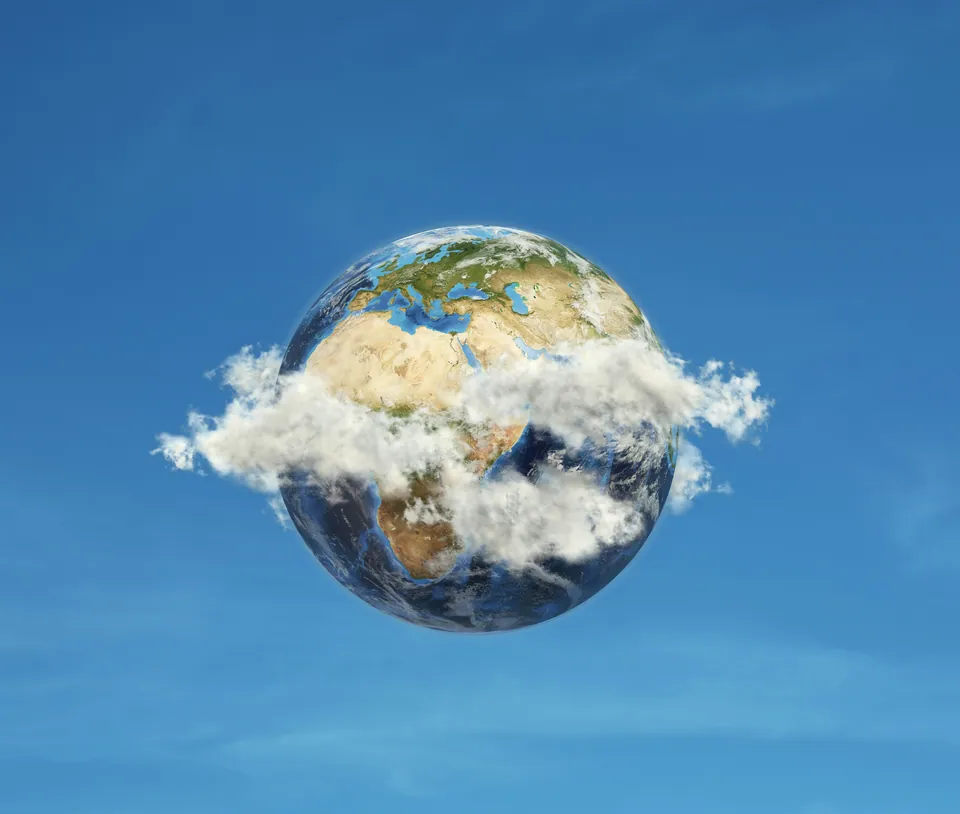 Earth globe wrapped in clouds on a blue sky