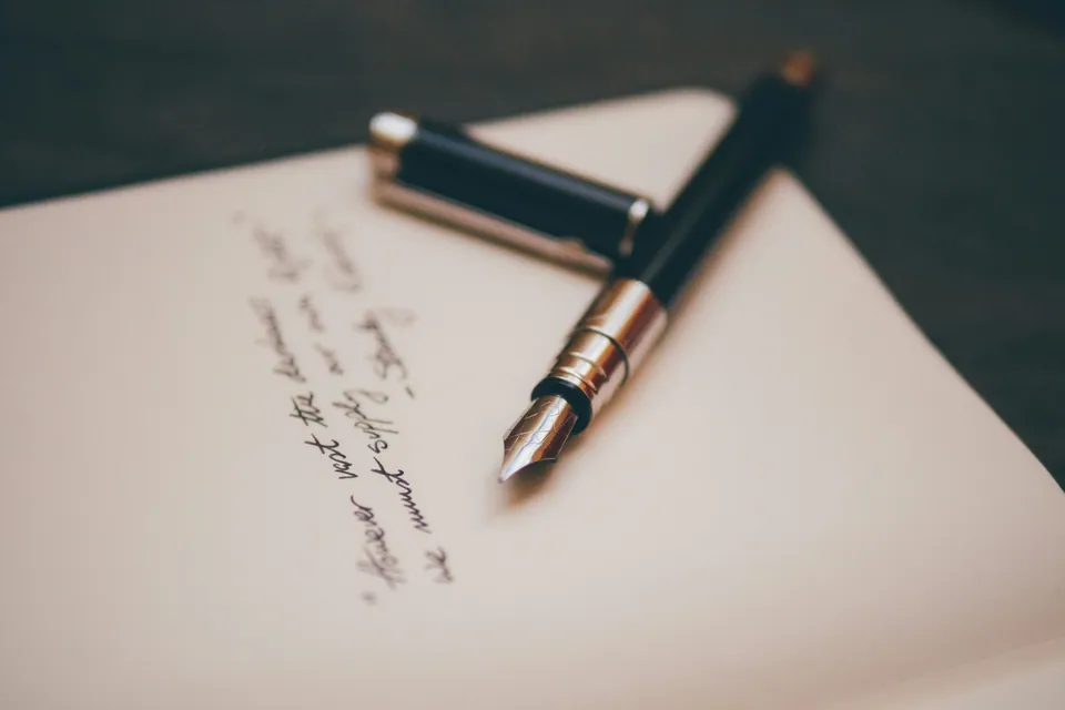 Fountain pen resting on a handwritten notebook page