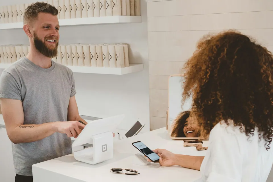 Customer paying by phone at a shop counter card reader