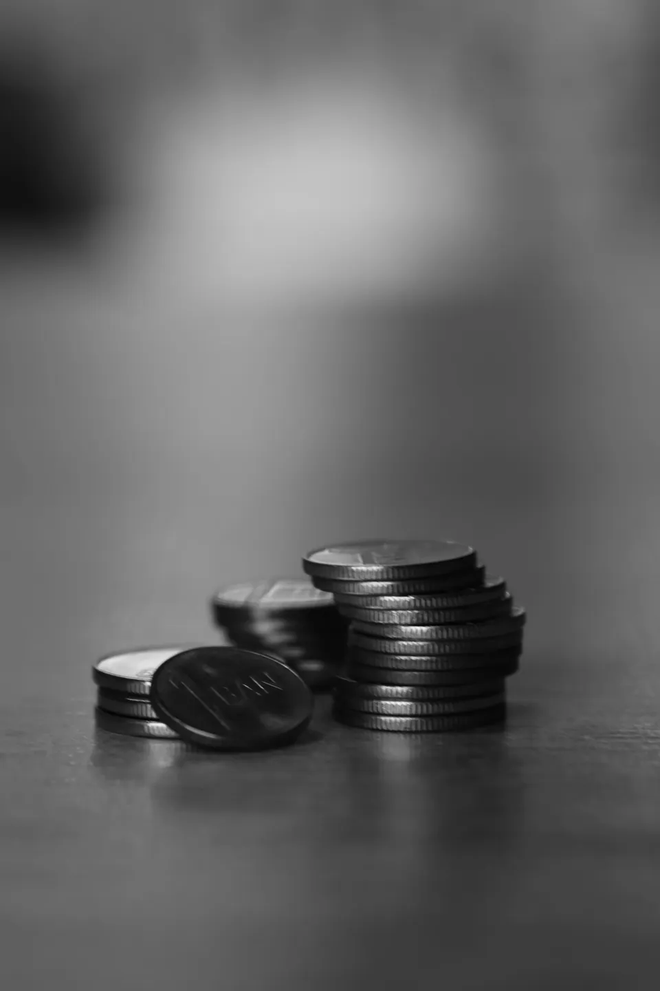 Black and white photo of small stacks of coins