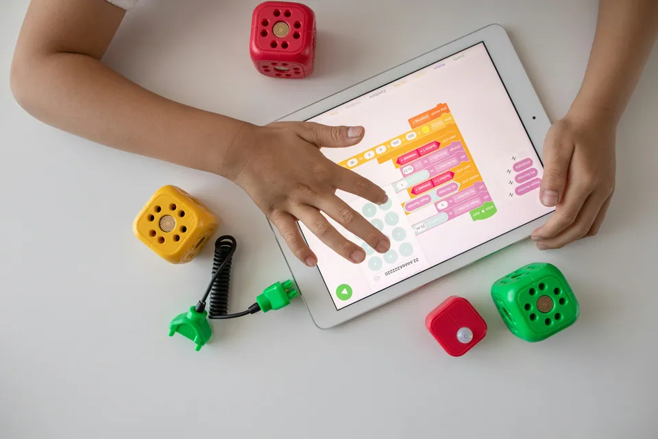 Child programming with colorful code blocks on a tablet