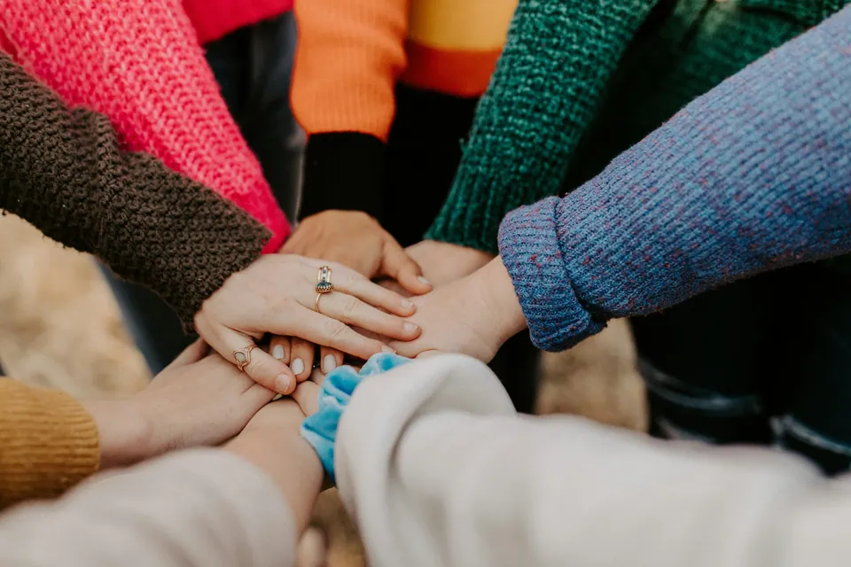 Team stacking hands together in a huddle