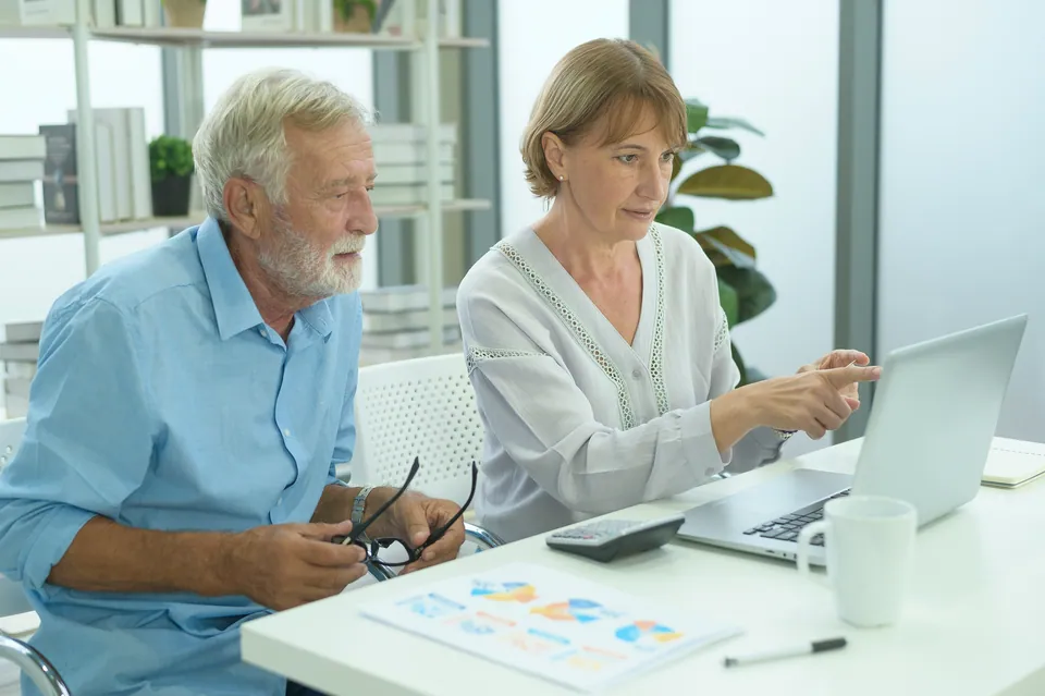Older couple reviewing a laptop together at a desk