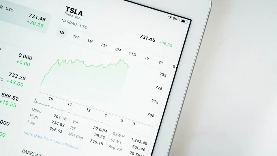 Tablet showing a TSLA stock price chart