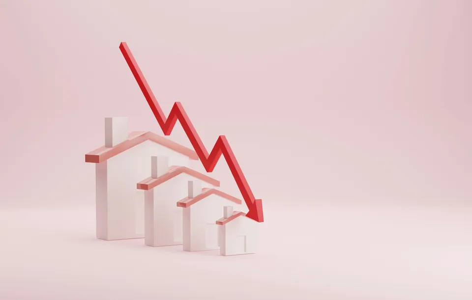 Red arrow falling over small model houses on a pink background