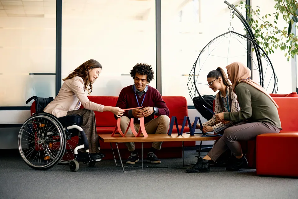 Diverse colleagues building a model together in an office lounge