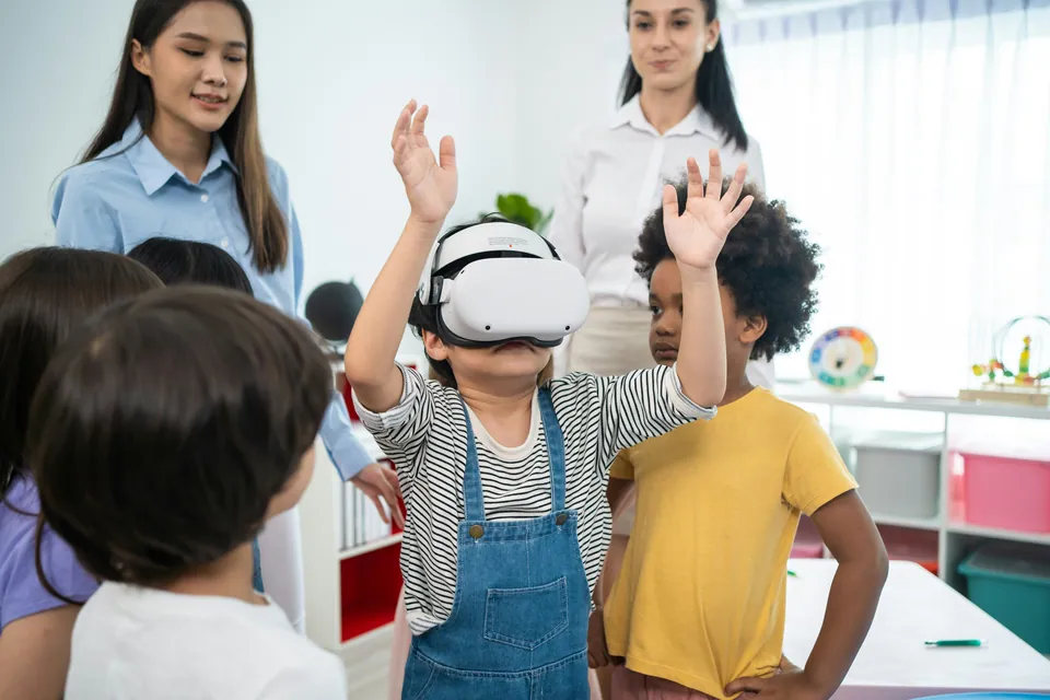 Child wearing a VR headset with classmates and teachers in a classroom