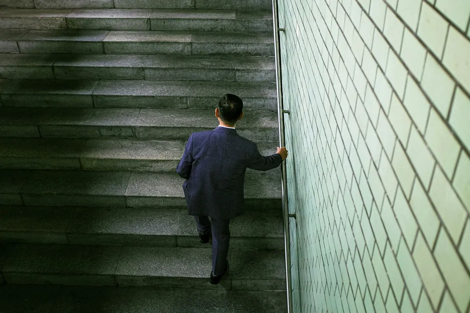Businessman walking up a wide stone staircase