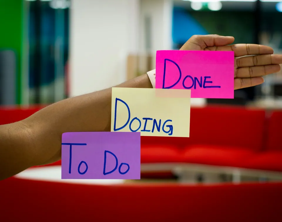 Hand holding To Do, Doing and Done sticky notes