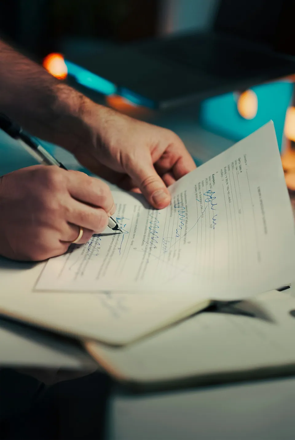 Hands signing a document at a desk