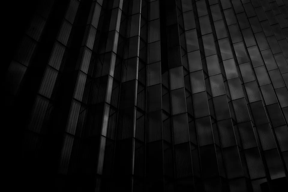 Dark glass office tower facade at night