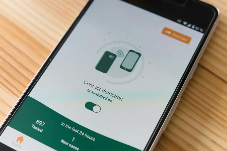Phone showing a contact detection app on a wooden table