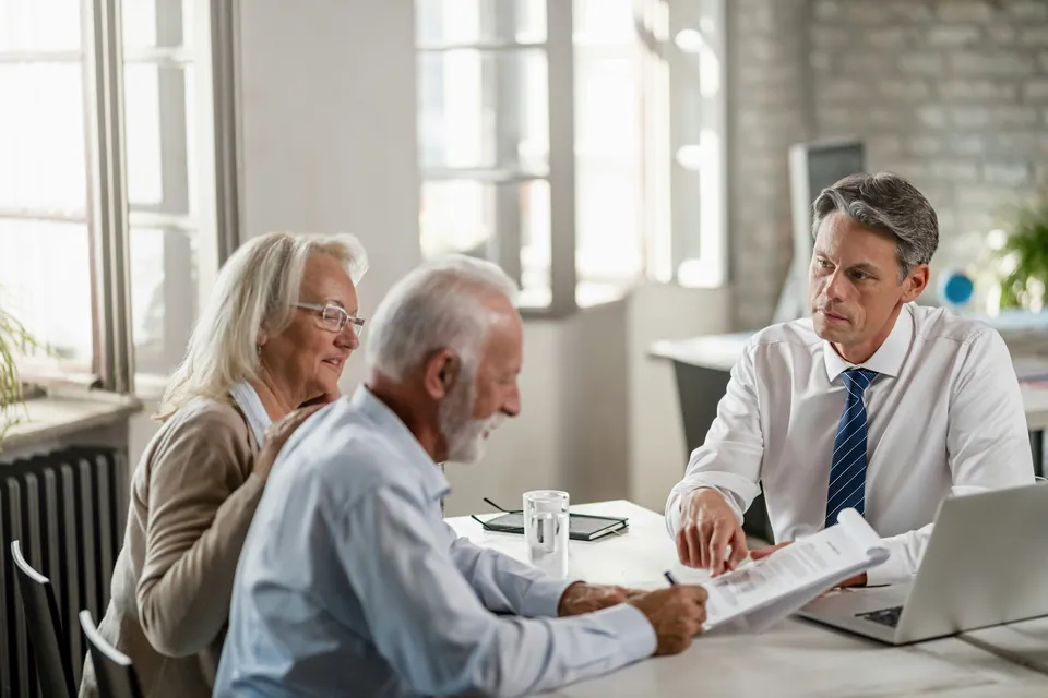 Advisor reviewing documents with an older couple at a desk