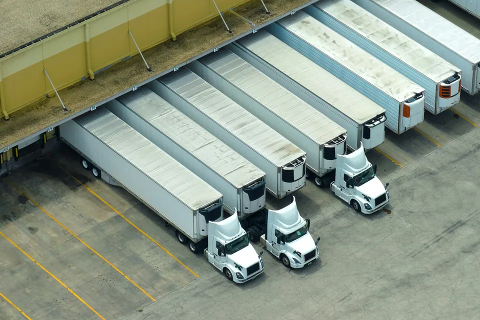 Aerial view of semi-trucks parked at warehouse loading docks