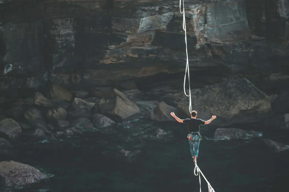 Person walking a slackline over a rocky gorge